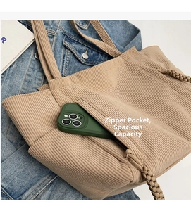 Dettaglio della borsa tote in velluto a coste kaki con tasca esterna con zip per cellulare