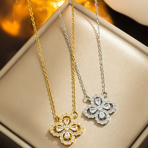 Detail showing gold and silver clover flower pendants with sparkling stones