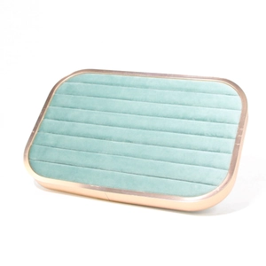 Macro view of mint green velvet jewelry tray with rose gold frame and ring slots