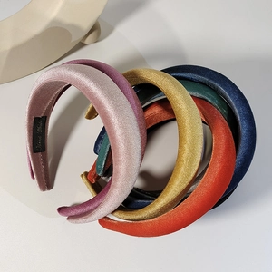 Macro shot of colorful velvet padded headbands in various rich shades on white background