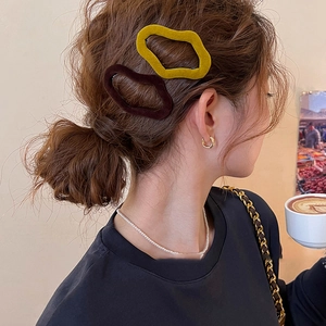 Flocked geometric hair clips in mustard and brown worn for a vintage velvet aesthetic
