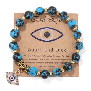 Detail of blue turquoise beads with an evil eye pendant on a display backing card
