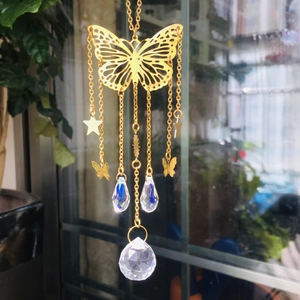 Detail view of golden butterfly suncatcher with crystal prisms and stars for garden decor