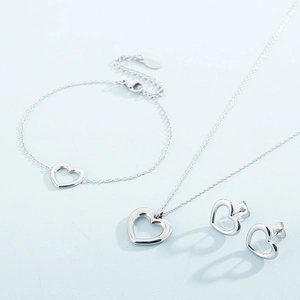 Elegant silver heart jewelry set featuring necklace, bracelet and stud earrings on blue base
