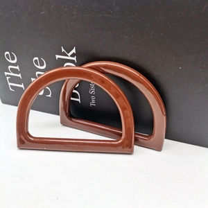 Close-up of a pair of brown D-shaped resin handles for DIY handmade woven bags