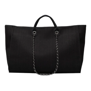 Large black canvas tote bag with textured weave and silver chain shoulder straps