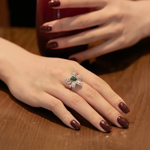 Close-up of S925 sterling silver bow ring with square emerald and clear zircon stones