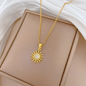 Elegant gold spinning sunflower pendant necklace with white crystals on a silk background