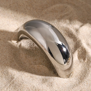 Polished silver metal hair ring displayed in warm sand showing sleek mirror finish details