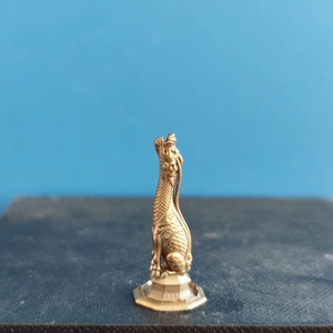 Detailed dragon beast statue showing bronze scale texture and octagonal base