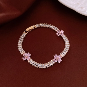 Detail of gold flower bracelet with pink heart petals and clear rectangle zircon stones