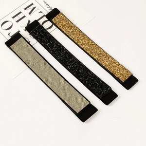 Detailed view of elastic rhinestone belts in silver, black, and gold on a fashion magazine