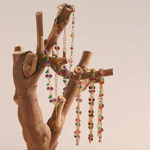 Détail des bracelets cerises en acier plaqué or 18K avec des fruits en émail coloré