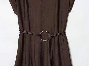 Détail d'une robe marron foncé avec ceinture à boucle dorée et texture à rayures fines