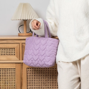 Close-up of lavender quilted heart handbag with soft texture and glossy finish