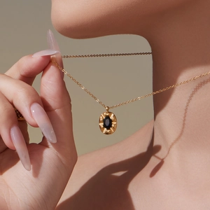 Elegant gold oval pendant necklace with black gemstone on minimalist steel chain