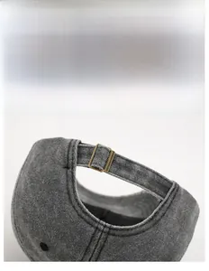 Detail view of adjustable bronze metal buckle and washed fabric on baseball cap back