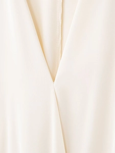 Vue détaillée du col en V en satin crème montrant la texture délicate du tissu soyeux