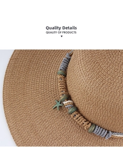 Detail of hand-woven straw hat with multi-color braided rope and bronze starfish pendant