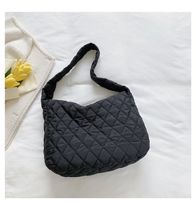 Detailed view of black quilted nylon dumpling bag with soft pleated texture and wide strap