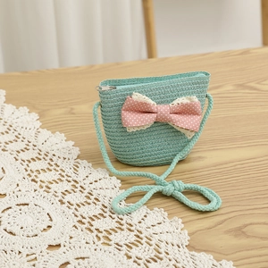 Detail of mint green straw crossbody bag for girls with polka dot bow and lace trim