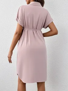 Back view of a mauve short-sleeve maternity shirt dress with adjustable waist tie