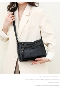 Detail of black crossbody bag featuring multiple zipper pockets and soft pebble leather texture