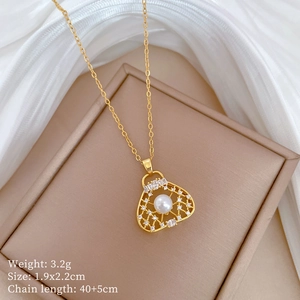 Close-up of gold hollow bag pendant with pearl and rhinestones on a jewelry box