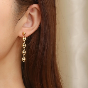 Detail of gold coffee bean link earrings on model showing elegant vertical drape