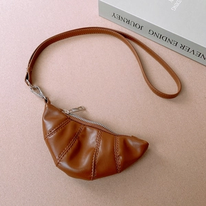 Detailed view of brown faux leather croissant pouch with pleats and silver zipper closure