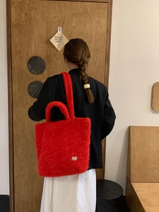 Dettaglio della borsa rossa in peluche con morbida pelliccia e logo a forma di cuore