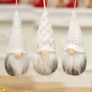 Three gray and white knitted Christmas gnomes hanging against a cozy interior background