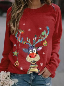 Close-up of red Christmas sweatshirt featuring reindeer and snowflake print on the street