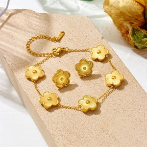 Golden stainless steel five-leaf clover necklace and earring jewelry set on stone