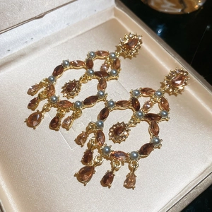 Macro shot of Baroque style gold drop earrings with amber crystals in a jewelry box