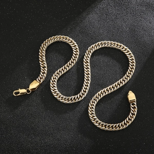 Detail of golden flat Cuban link chain with secure lobster clasp on black background