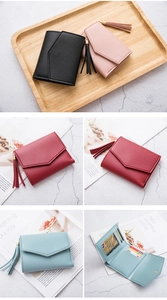 Dettaglio di portafogli corti in pelle PU con nappe in nero, rosa, rosso e blu
