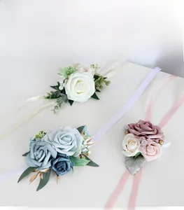 Detailed view of artificial rose wrist corsages with silk ribbons in white, blue, and pink