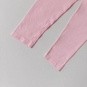 Detailed close-up of pink yoga pants featuring high-elasticity flatlock seams and cuffs