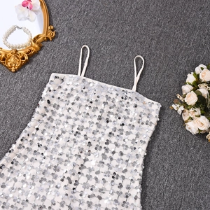 Détail de paillettes argentées scintillantes sur une robe à fines bretelles doublée