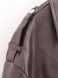 Detail view of brown PU leather jacket featuring shoulder epaulets and metal buckles