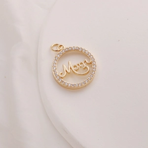 Macro detail of a 14K gold-plated circular pendant with Mom text and zircon inlay