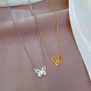 Dettaglio di collane con farfalla in oro e argento su seta rosa e bianca di qualità