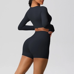 Detail van de zwarte yogaset met een hoge taille short met zak en gladde sportieve stof