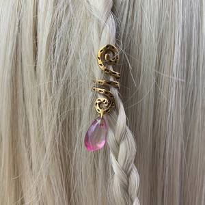 Detail of gold spiral hair cuff with pink teardrop pendant on braided blonde hair