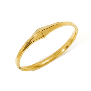 Macro detail of minimalist 18K gold plated geometric stainless steel bangle with polished finish