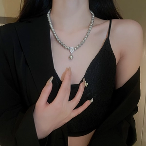Detailed view of model wearing a grey pearl necklace with a zircon teardrop pendant
