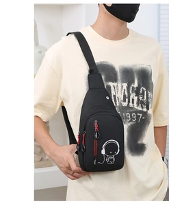 Detail of black crossbody bag with astronaut print and distinctive red zipper puller