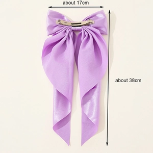 Oversized purple satin bow hair clip with long ribbons and a silver metal spring clasp