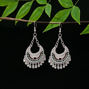 Detailed shot of ethnic silver earrings with hollow crescent shape and colorful beads